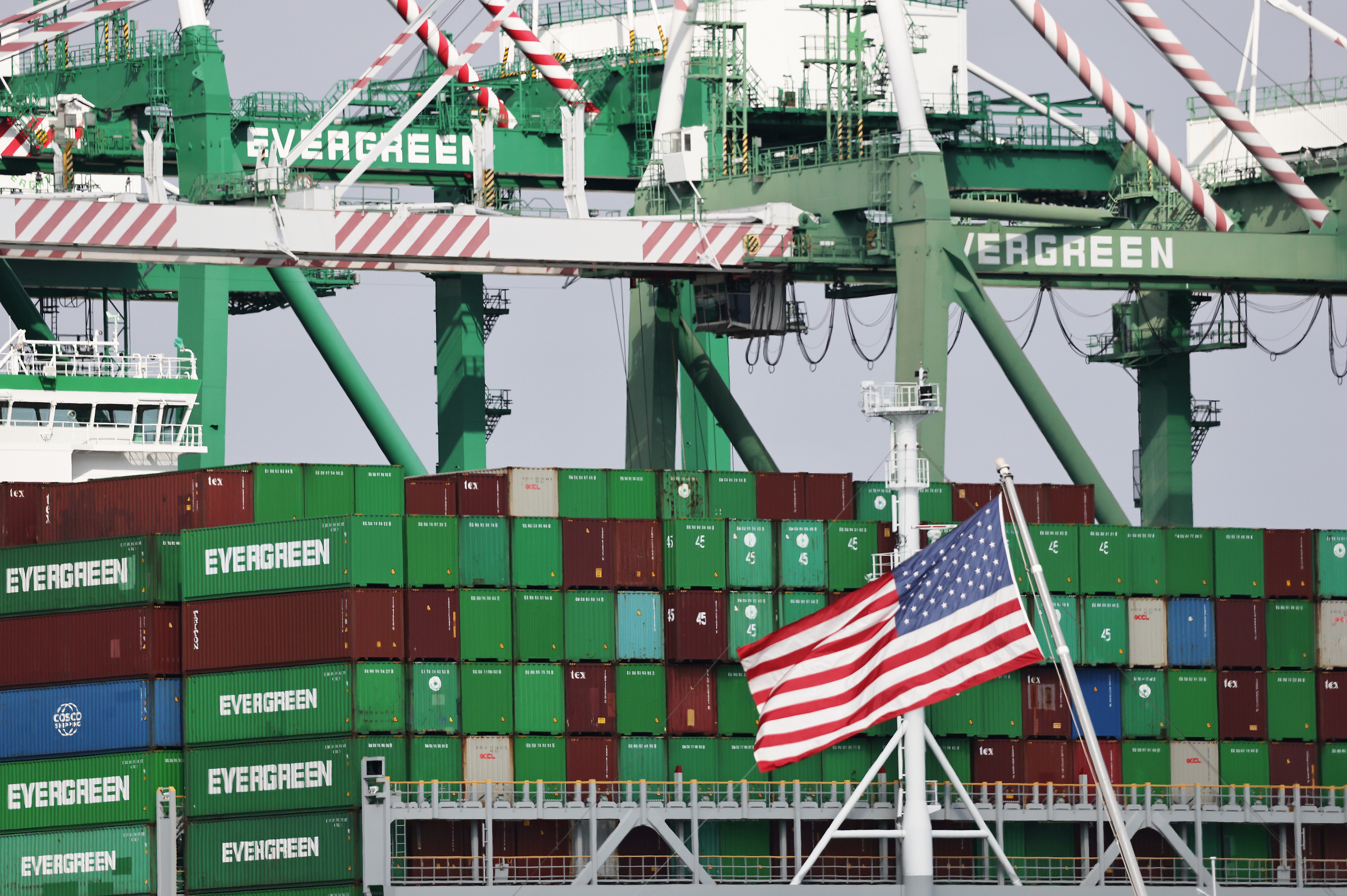 An American flag flies near shipping containers at the Port of Los Angeles on Sept. 26.